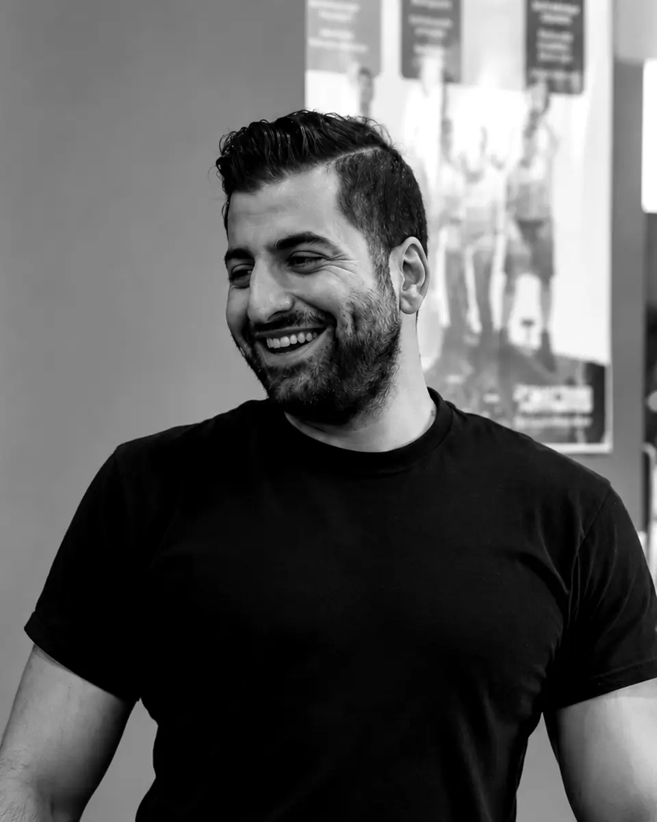 Shayan, certified personal trainer, smiling in a black t-shirt