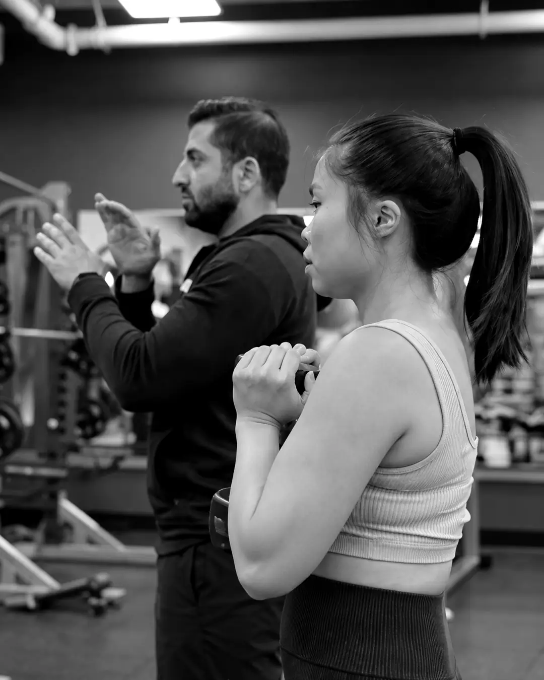 Shayan coaching a client's form during a standing exercise
