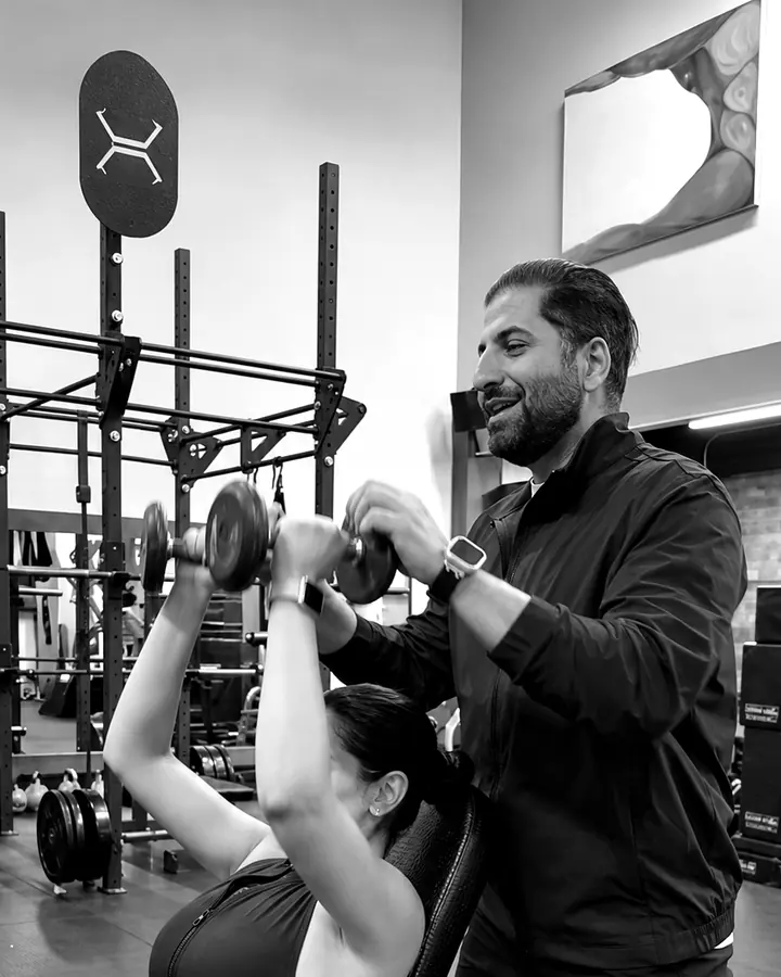 Shayan spotting a client on an incline dumbbell press in Vancouver