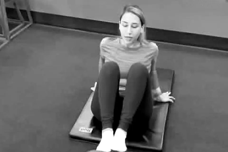 Client doing core work on a mat during a fat-loss session